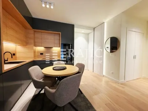 Modern kitchen with a dining table and grey cabinets. - image 4