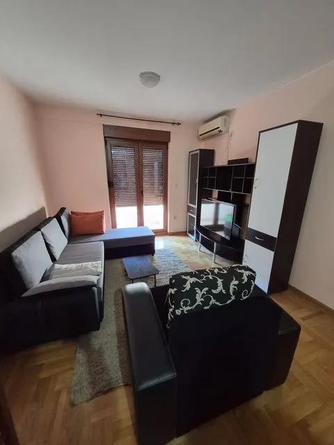 Living room with a sofa, TV, and wardrobes.