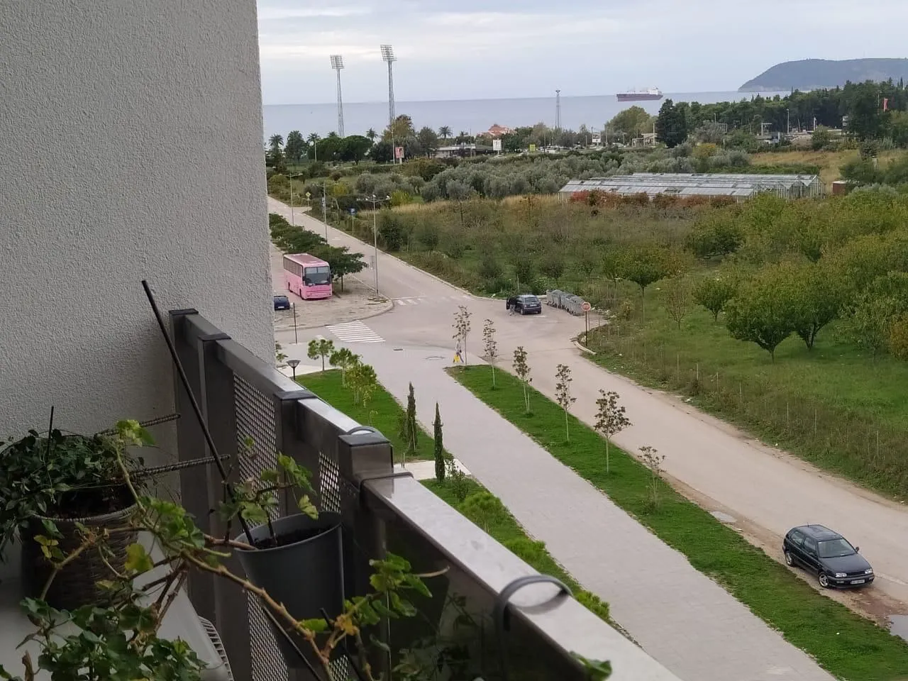 View from the balcony overlooking the surroundings, street, and sea.