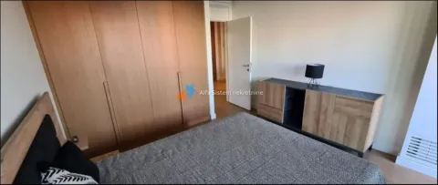 Furnished bedroom with a large wooden wardrobe and a double bed. - image 10