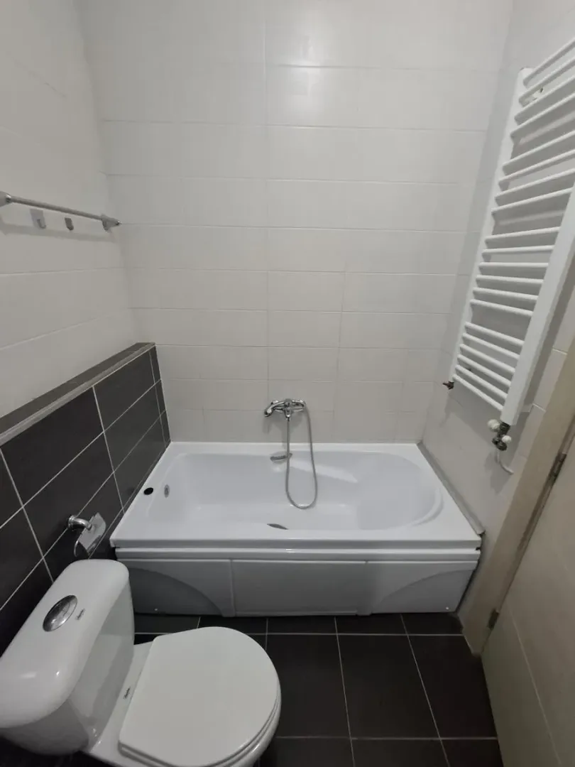 Kupatilo opremljeno kadom, toaletom i radijatorom za peškire.