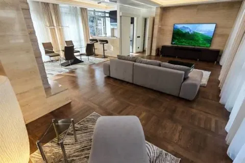 Spacious living room with a sofa, TV and dining area in the background. - image 10