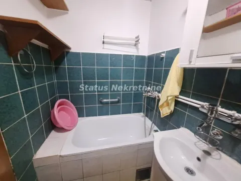 Manje kupatilo sa kadom, umivaonikom i zelenim zidnim pločicama. - image 2