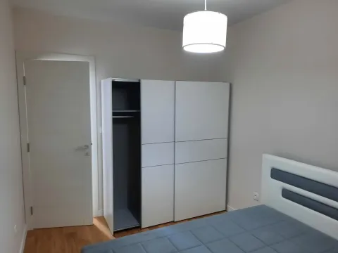Bright bedroom with a white sliding wardrobe and a modern bed. - image 7