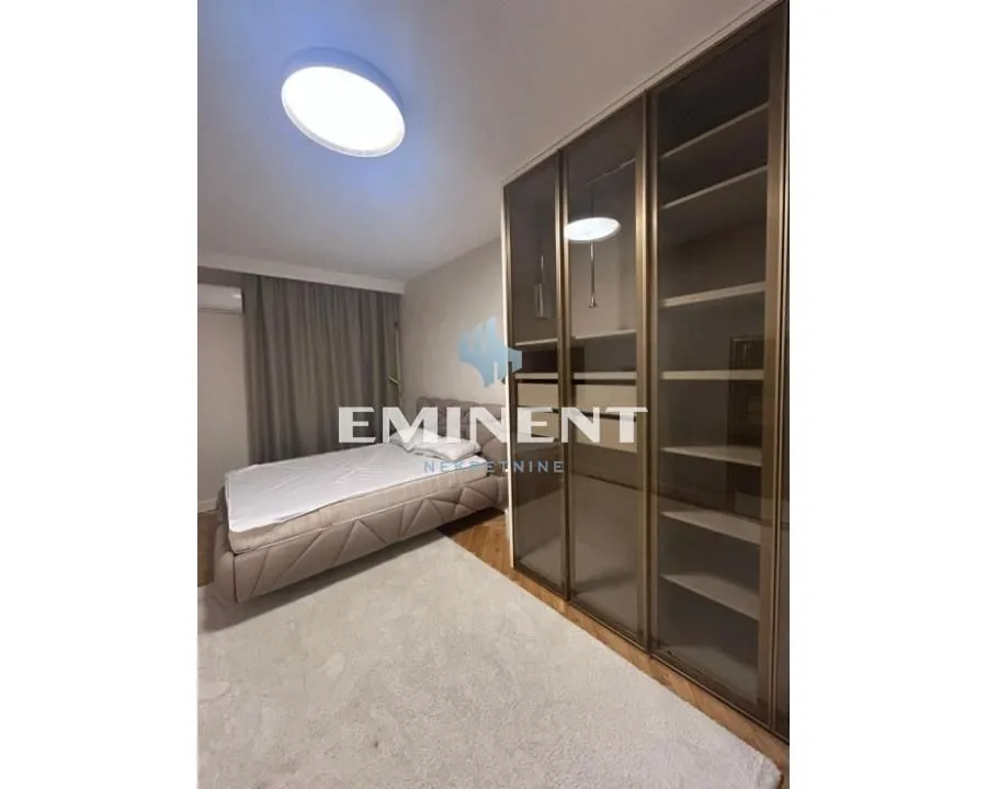 Furnished bedroom with a double bed and a large built-in wardrobe.