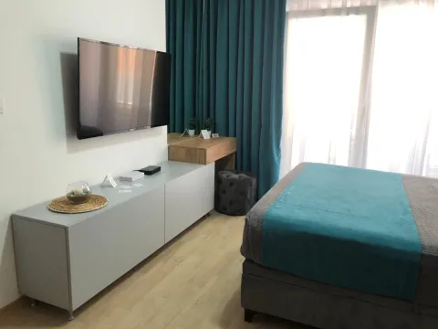 Namještena spavaća soba sa bračnim krevetom, televizorom na zidu i radnim stočićem. - image 3