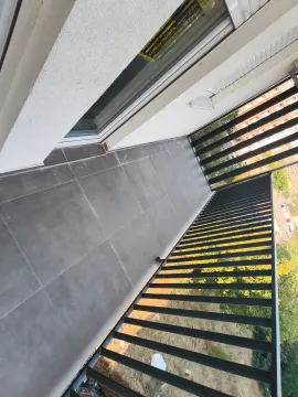 View of the spacious balcony with dark tiles and a metal railing. - image 12
