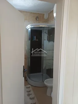Pogled na kupatilo sa tuš kabinom kroz otvorena vrata. - image 6