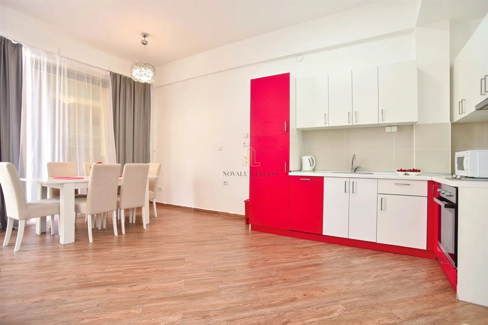 Modern kitchen with a dining area and red-and-white cabinetry.