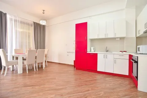 Modern kitchen with a dining area and red-and-white cabinetry. - image 7