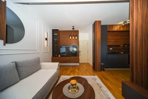 Dnevna soba povezana sa kuhinjom, opremljena modernim namještajem. - image 3