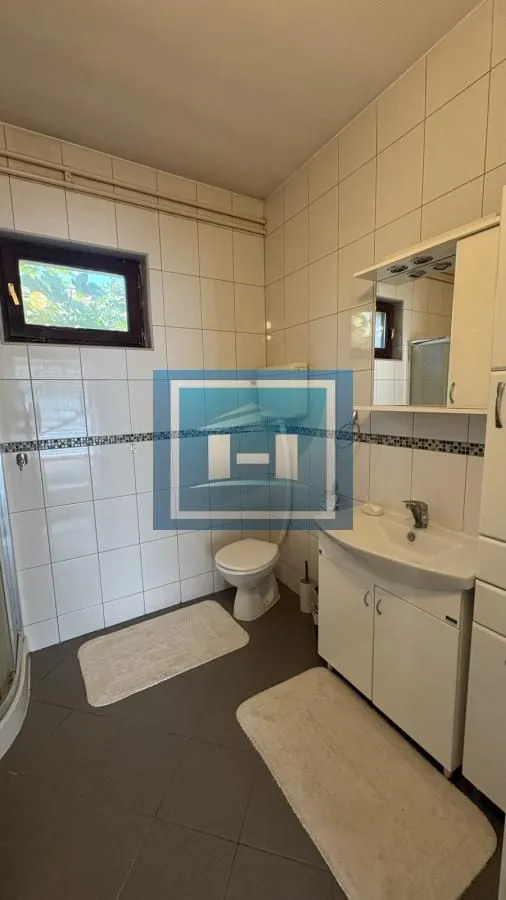 Kupatilo obloženo keramičkim pločicama sa umivaonikom i toaletom.