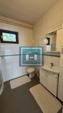 Kupatilo obloženo keramičkim pločicama sa umivaonikom i toaletom. - image 19