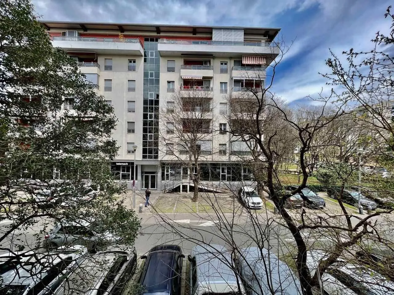 View of a multi-story residential building surrounded by trees.