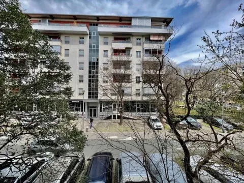View of a multi-story residential building surrounded by trees. - image 11