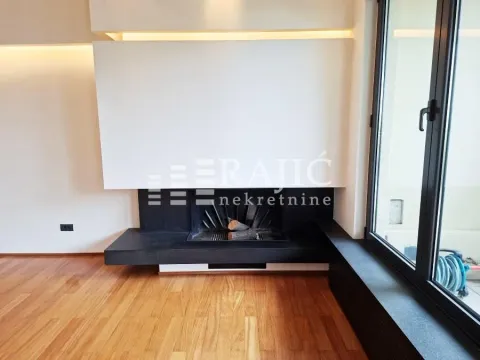 Living room with a modern fireplace and wooden floor. - image 4