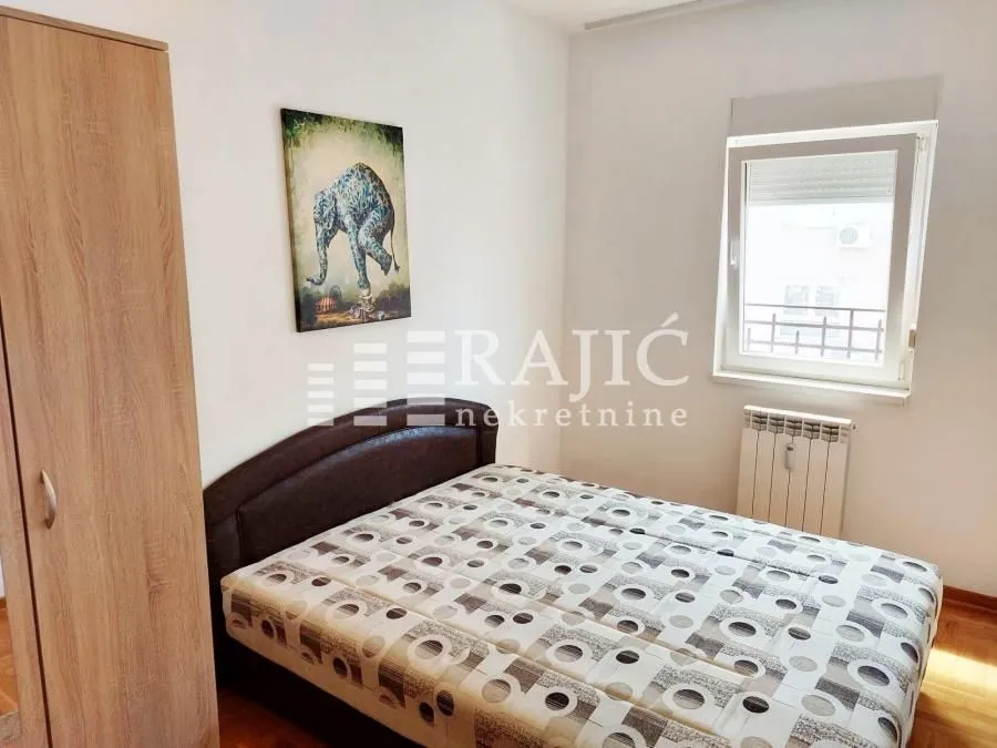 Furnished bedroom with a double bed, wardrobe, and a window.