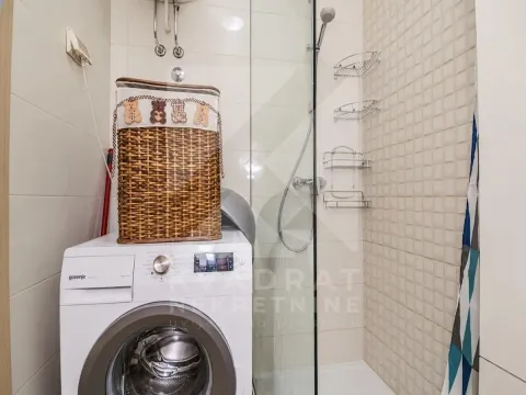 Bathroom with a shower cabin, washing machine, and wicker laundry basket. - image 4