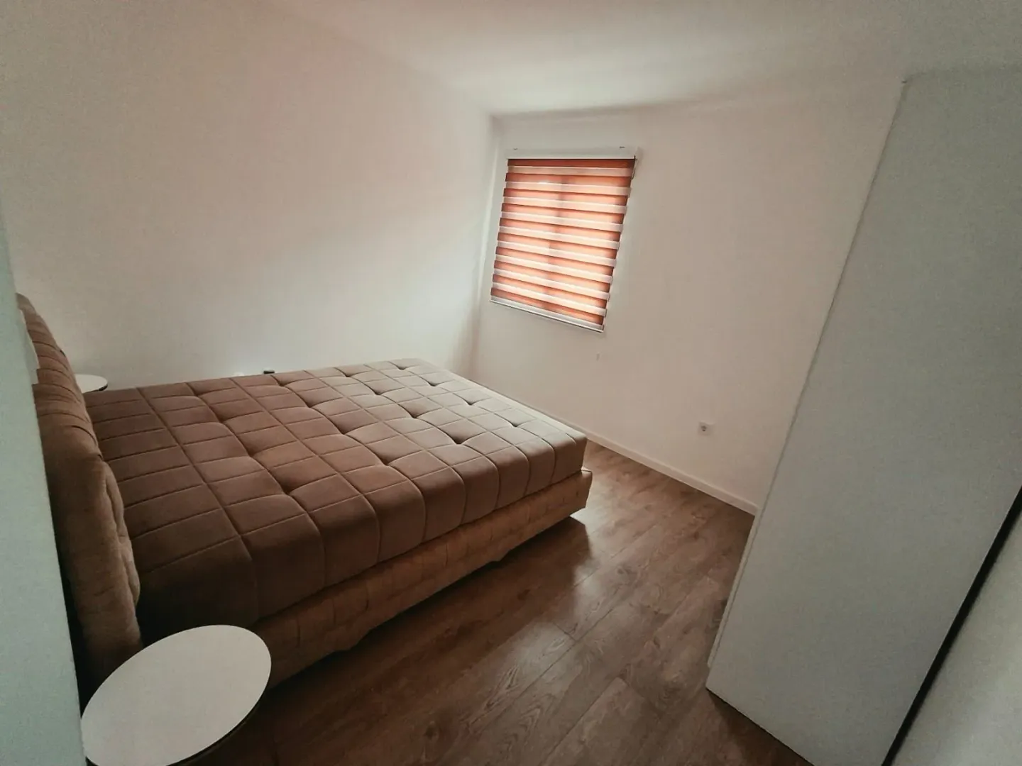 Furnished bedroom with a double bed and a window.