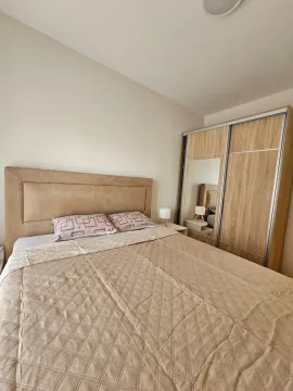 Furnished bedroom with a double bed and a wooden wardrobe. - image 7