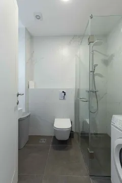 Savremeno opremljeno kupatilo sa tuš kabinom i veš mašinom. - image 22