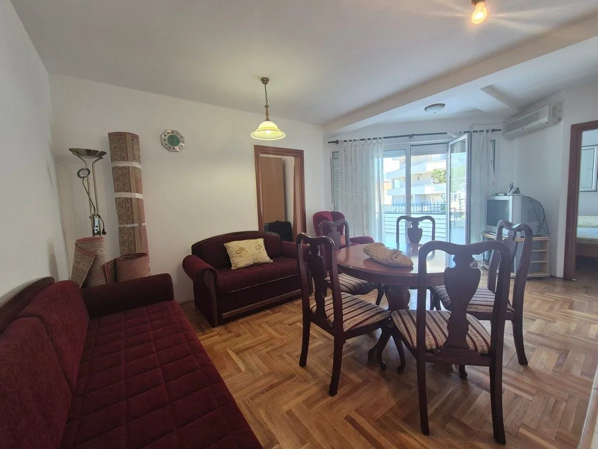 Living room with a seating set, dining table, and access to the terrace.