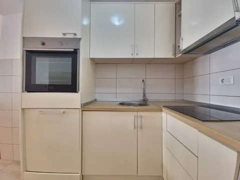 Kitchen with light cabinets, built-in oven, and a sink. - image 24