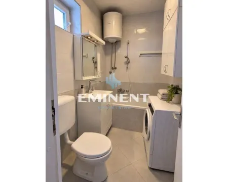Smaller bathroom with a shower cabin, washbasin, toilet, and washing machine. - image 7