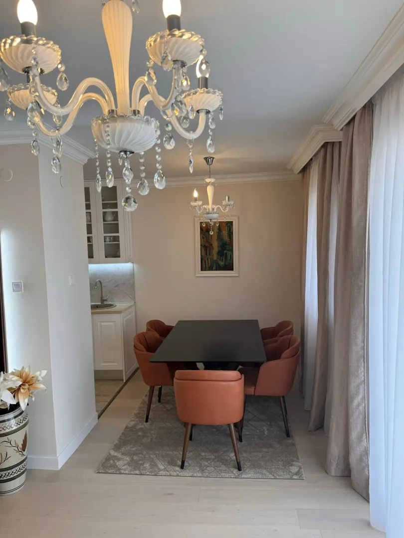 Dining area with a black table and orange chairs.