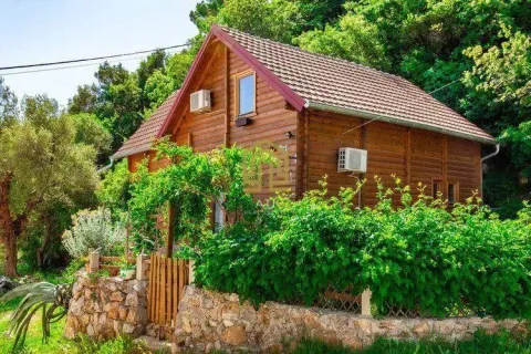 Exterior view of a wooden house with a landscaped yard and greenery. - image 18