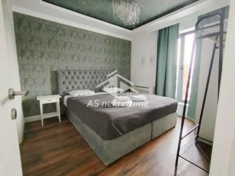 Furnished bedroom with a double bed and a wallpapered accent wall. - image 16