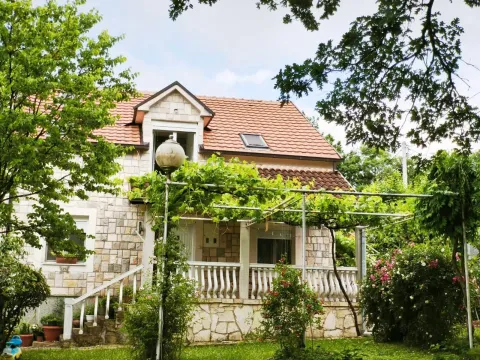 Pogled na dvorište i fasadu kuće sa kamenom oblogom i terasom. - image 7