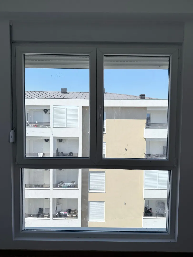 Pogled kroz prozor na susjednu zgradu.