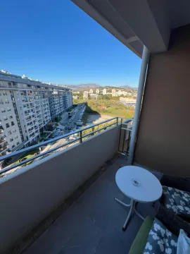 Covered balcony with seating furniture and a view of the neighborhood. - image 11