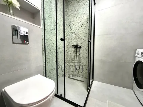 Moderno opremljeno kupatilo sa tuš kabinom i veš mašinom. - image 12