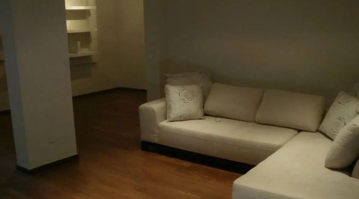 Living room with a corner sofa and wooden flooring.