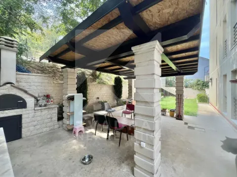 Covered porch with an outdoor barbecue and seating set in the yard. - image 11