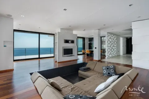 Spacious living room with a comfortable sectional sofa, fireplace, and sea view. - image 3