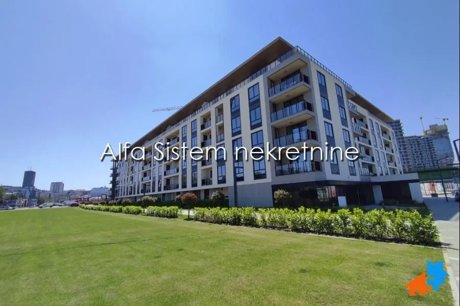 View of the exterior of a modern residential building with a landscaped lawn.