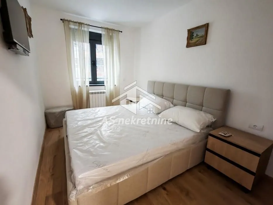 Furnished bedroom with a double bed and a bedside table.