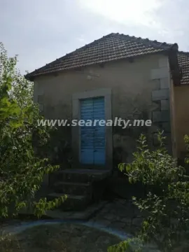 Pogled na spoljašnjost tradicionalne kamene kuće sa plavim drvenim vratima i stepeništem. - image 5