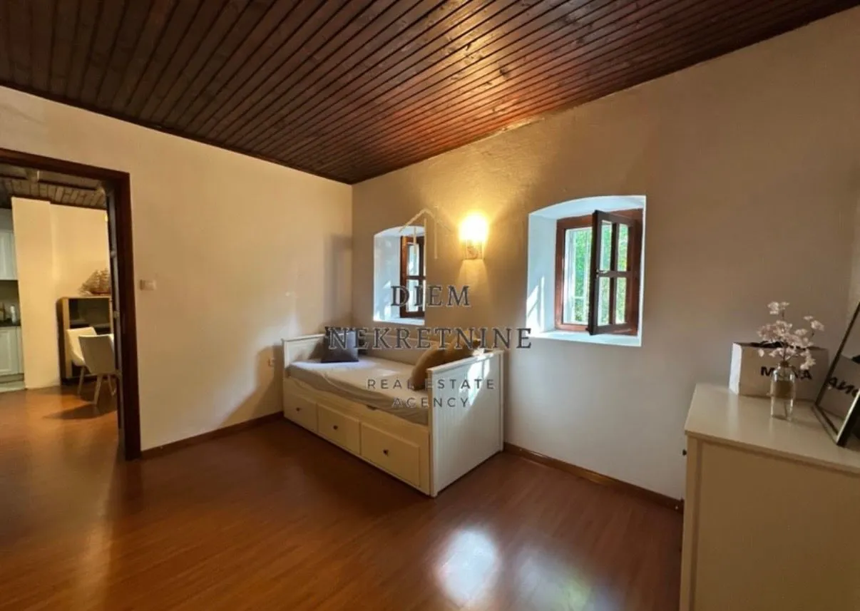 Small bedroom with a bed and a wooden ceiling.