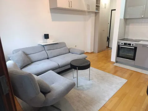 Living room with a sofa set and a kitchen corner in the background. - image 5