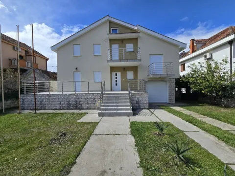 Front view of a two-story family house with a landscaped yard. - image 4