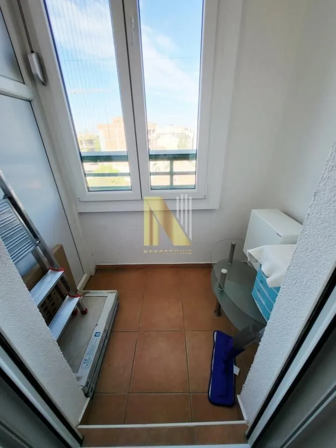 Manji zastakljeni balkon sa keramičkim pločicama na podu.