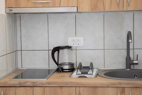 Dio kuhinje sa radnom pločom, sudoperom i električnim kuvalom. - image 7