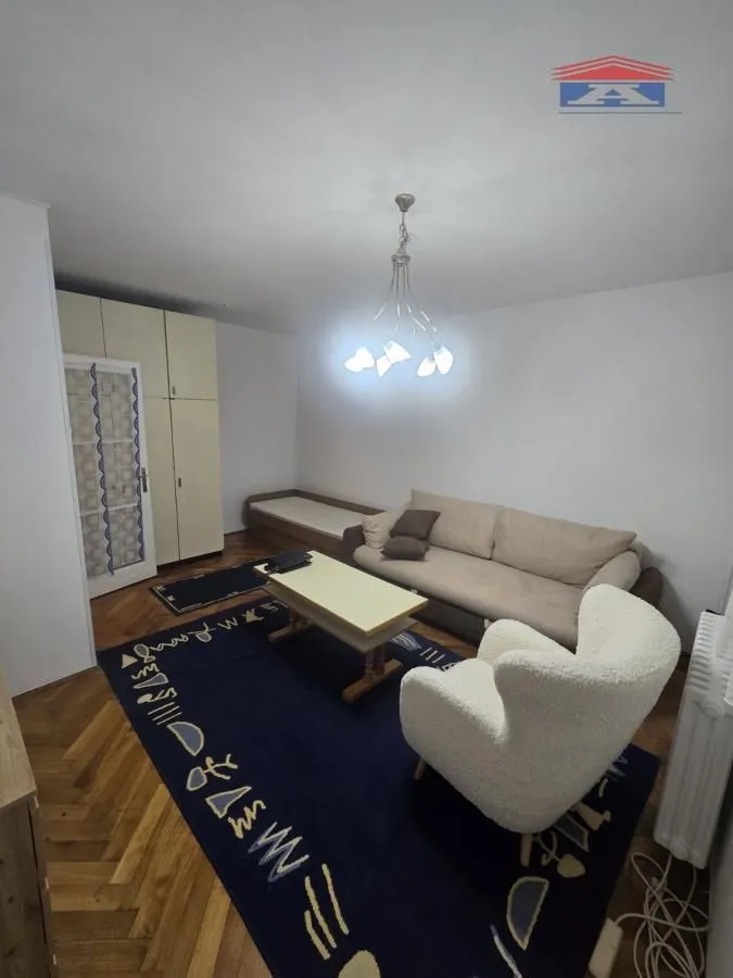Dnevna soba sa garniturom za sedenje, stočićem i tepihom.