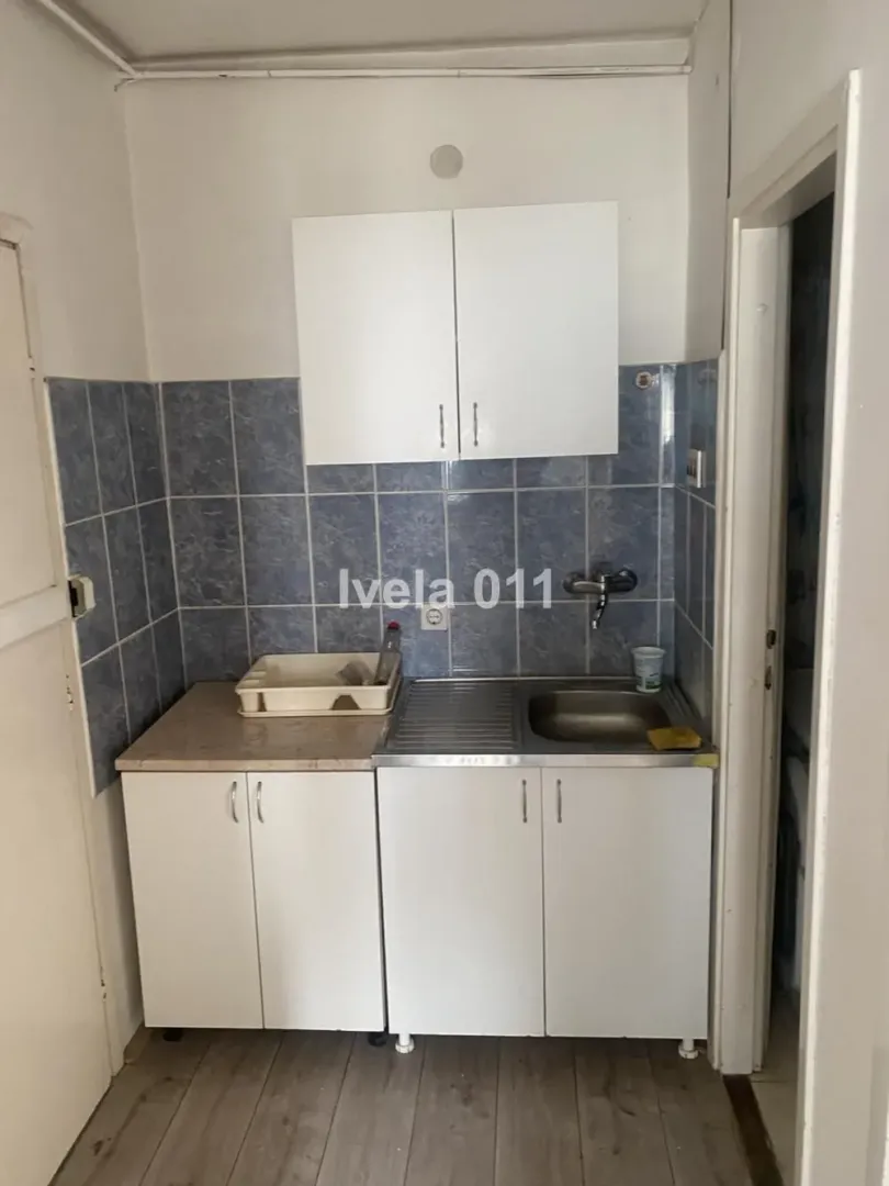 Small kitchen with white cabinets and a sink.