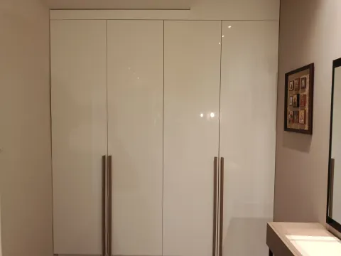 Built-in wardrobe with glossy white fronts and long handles. - image 19