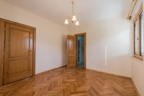 An empty room with parquet flooring and wooden doors. - image 4